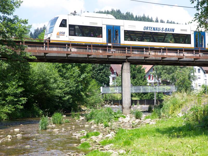 Ein Zug fährt über eine Brücke über die Kinzig.